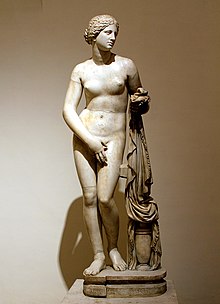 Sculpture of a standing female nude, covering her vulva with one hand.