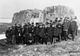 A group of men standing in front of Parry's wintering rock in 1909