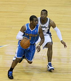 Chris Paul, dribblant de la main droite pour échapper à un adversaire