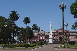 La Plaza de Mayu (Buenos Aires), cola pirámide nel so centru y la Casa Rosada al fondu. Les protestes de les Madres de Plaza de Mayu pa reivindicar la memoria de los sos fíos sumíos pola dictadura arxentina facer famosa en tol mundu.