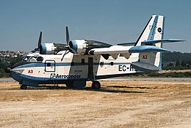 vue de profil d'un canadair blanc et bleu au sol.