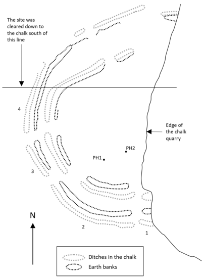 Approximately semi-circular arcs of ditches and banks, truncated by the edge of a quarry