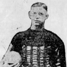 A grainy black and white photo of Lewellen in his Packers uniform holding a football.