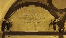 A marble gravestone on the wall of a crypt