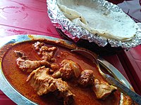 Món cà ri gà từ Maharashtra, Ấn Độ với bánh chapati bột gạo. Đây là món ăn được ưa chuộng trên toàn thế giới.[35]
