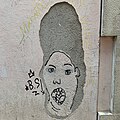 Grafiti en la pared de una calle de Mataró, aprovechando el desconchado para representar el cabello de Marge Simpson, 2021