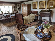 The bedroom of a Tudor cottage, decorated with antique furniture