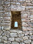 Detalle de una ventana trapezoide, posiblemente enlucida y pintada.