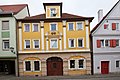 Fassade eines reich gegliederten dreigeschossigen Bürgerhauses und Holztor