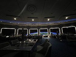 Modern dining area with a simulated view of the earth from space through windows along the wall