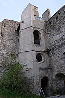 Tour collée à un mur avec plusieurs fenêtres à chaque étage.