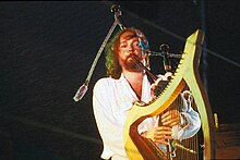 Alan Stivell à la cornemuse derrière sa harpe à Lorient.