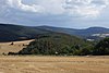 Burg, von Nordwesten gesehen, oberhalb Reichenbachs, links am Bildrand der Berg Windhain, darüber lugen die Türme des Großen Feldbergs hervor, mittig am Horizont Kleiner Feldberg, sowie davor der Weilsberg, der nach links in den Hühnerberg übergeht, hinten rechts der Glaskopf über den Häusern von Oberems sowie wiederum darunter Wüstems