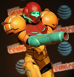 Femme dans un costume de Samus Aran de couleur jaune et rouge (cosplay).