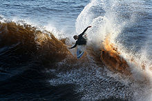 Photo of surfer wiping out with arms outstretched and body parallel to surface