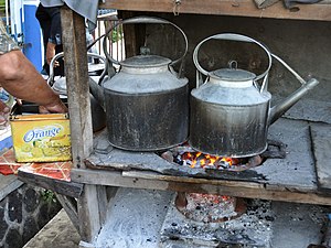 Pedagang angkringan sedang memasak air dengan cerek