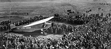 Photographie de la foule et de l'avion arrêté.