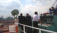 Containerschiff beim Anlegemanöver, Kapitän am Fahr- und Steuerstand in der Backbord-Brückennock – 2009