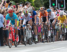 A cyclist riding a bike while wearing a skinsuit and an aerodynamic helmet.