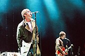 Vocalist Liam Gallagher and guitarist Noel Gallagher performing on stage