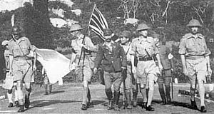 Generalløjtnant Arthur Percival, ledet af en japansk officer, gå under et hvidt flag for at forhandle om kapitulation af de allierede styrker i Singapore, den 15. februar 1942. Det var den største overgivelse af britisk-ledede styrker i historien.