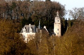 Vue générale d'un châteauau flanc d'un coteau. Tour cylindrique à droite.