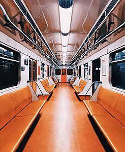 Интерьер вагона Ереванского метрополитена в оранжевой окраске со сплошной обивкой сидений