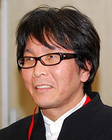 Close-up photo of man in suit with glasses