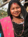 Nepalsk kvinne med påklistra bindi mellom augebryna og rund måla flekk ved hårfestet. Foto: Yves Picq