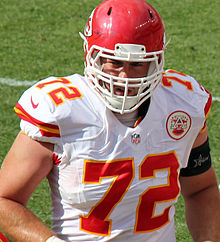 Eric Fisher in a Kansas City Chiefs helmet and uniform while on an NFL field.