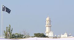 Ahmadiyyaflaggan och den vita minareten i Qādiān i Indien. Dessa två ting symboliserar ankomsten av den utlovade Mahdi och Messias.
