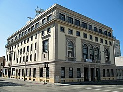 A five-story tan building seen at an angle, with the front entrance to the right.