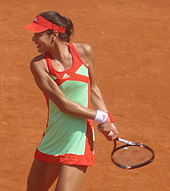Une joueuse de tennis prépare son revers à deux mains.