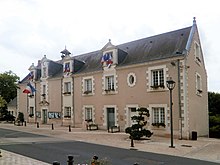 Photographie d'un bâtiment dont la façade est ornée de drapeaux français.