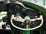photographie en couleur montrant le manche en forme de demi-volant du copilote, avec les cadrans des instruments de la planche de bord en arrière-plan