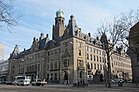 Photographie en couleurs de la façade d'un bâtiment public et de son environnement urbain.