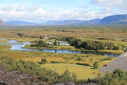 Vue de la partie septentrionale des Þingvellir depuis le rebord sud-ouest du horst avec au premier plan la Öxará, dominés à droite par la Hrafnabjörg ; à gauche au dernier plan se trouve le Skjaldbreiður.