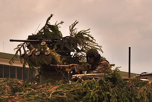 Un soldat avec un HK MG5, sur le dessus d’un véhicule blindé GTK Boxer