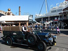 A black turn-of-the-20th-century-style car with no roof