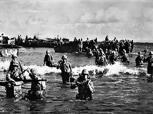 Amerikanske marinesoldater vader i land på Tinian.