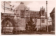Photographie ancienne d'un édifice comportant un porche médiéval et une façade de l'époque moderne