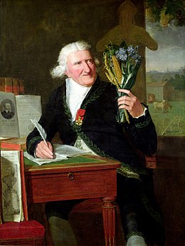Portrait de Parmentier assis dans son cabinet, en habit d’académicien, tenant un bouquet de toutes les plantes qu’il a étudiées, par François Dumont, 1812.