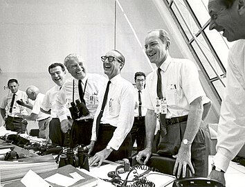 Ugyanaz az esemény az irányítóközpontban: Charles W. Matthews, az emberes űrrepülésekért felelős helyettes NASA főigazgató, von Braun, George Mueller, az emberes űrrepülések irodájának vezetője, Samuel C. Phillips tábornok az Apollo-program igazgatója az Apollo–11 startja után