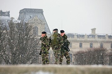 Déploiement militaire du plan Vigipirate sous la neige devant le musée du Louvre à Paris, décembre 2009.