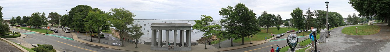 Plymouth Harbor with the Mayflower II (left, behind trees), Plymouth Rock (middle) and Cole's Hill (right) with the Statue of Massasoit