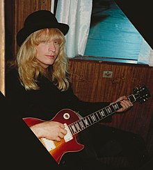 Fowler seated with a guitar