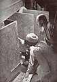 Howard Carter (klečící), Egyptský dělník a Arthur Callender u dveří svatyní hrobky