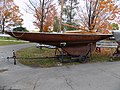 A wooden Dragon keelboat on its trailer showing the keel shape.