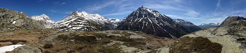 Il Colle del piccolo Moncenisio. Da sinistra: il Monte Malamot (2.917 m) con in cima il forte, la Cima di Bard (3.168 m), il Monte Giusalet (3.313 m), che si erge sul Vallone delle Savine, dove sono presenti il lago Savine o lago delle Savine (2.447 m) e il Colle Clapier (2.491 m); subito sopra i Denti d'Ambin (3.372 m), poi la Rocca d'Ambin (3.378 m), sotto il quale è collocato il Vallone d'Ambin, (dove si trova il Rifugio d'Ambin) che porta al Colle d'Ambin (2.897 m); sopra il vallone il Monte Ambin (3.264 m), la Punta Sommeiller (3.333 m), sopra il Colle del Sommeiller a 2.993 m s.l.m.). Davanti a questo la Roche d‘Etache (3.083 m) che copre la Pierre Menue (o Aiguille de Scolette) (3.506 m), della quale (sulla destra della precedente montagna) si nota il crinale che scende verso la Moriana sulla quale si erge il Massiccio della Vanoise. Alla destra del colle è visibile parte della Pointe de Bellecombe (2.755 m). Tutte le montagne elencate sono parte del Gruppo d'Ambin, tranne la Pierre Menue che appartiene all'omonimo gruppo e la Vanoise che costituisce un supergruppo alpino a sé stante.