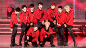 Exo performing onstage in red and black outfits